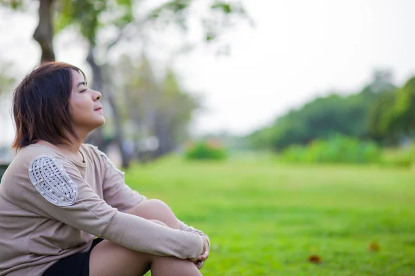 Portret Aziatische vrouw zitten in het park. — Stockfoto