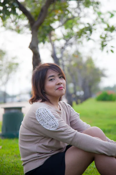 Retrato Mulher asiática sentada no parque . — Fotografia de Stock