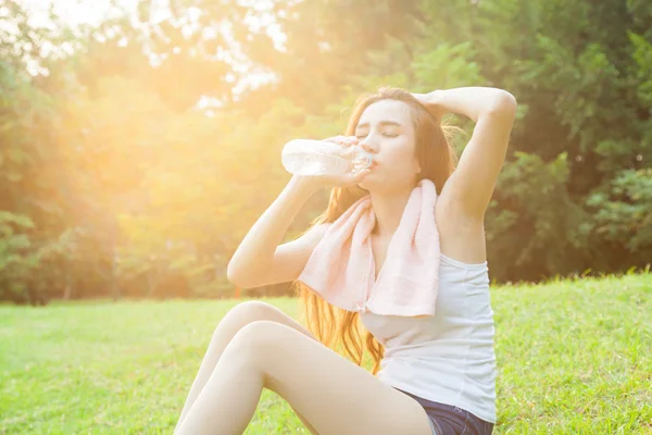 Asian woman are drinking and sitting on the lawn. — Stock Photo, Image