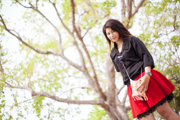 Asiatico donne nero camicia standing sotto un albero . — Foto Stock