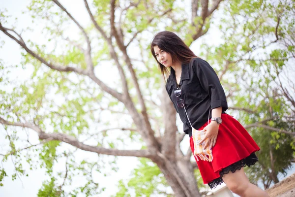 Asiatische Frauen schwarzes Hemd steht unter einem Baum. — Stockfoto