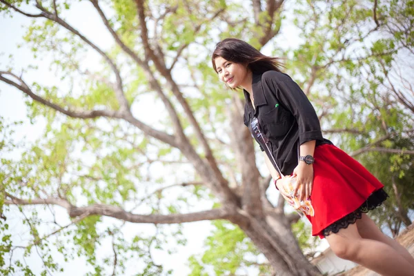 Asiática mujer negro camisa de pie bajo un árbol . — Foto de Stock