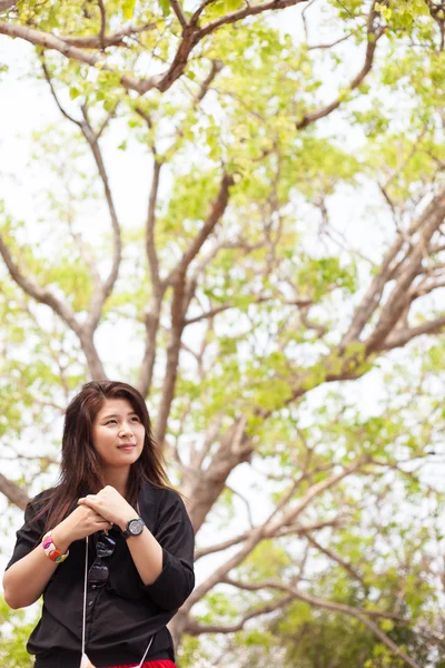 Азіатські жінки чорна сорочка стоїть під деревом. — стокове фото