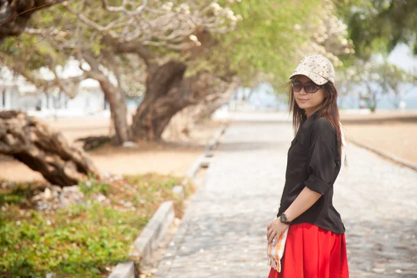 Asiatische Frauen schwarzes Hemd steht auf einem Gehweg — Stockfoto