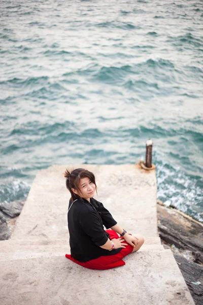 Mujer asiática camisa negra. Sentado en la acera . —  Fotos de Stock