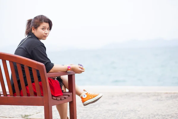 Asian women black shirt. Sitting on wooden bench. — Stock Photo, Image