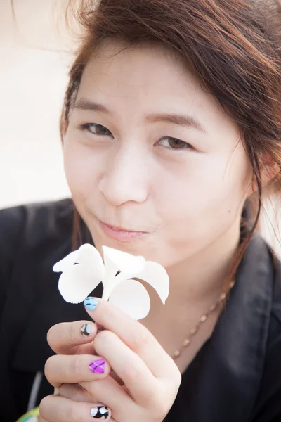 Asiatische Frauen schwarzes Hemd. weiße Blume in der Hand. — Stockfoto