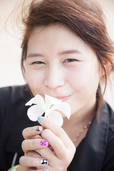 Asiatische Frauen schwarzes Hemd. weiße Blume in der Hand. — Stockfoto