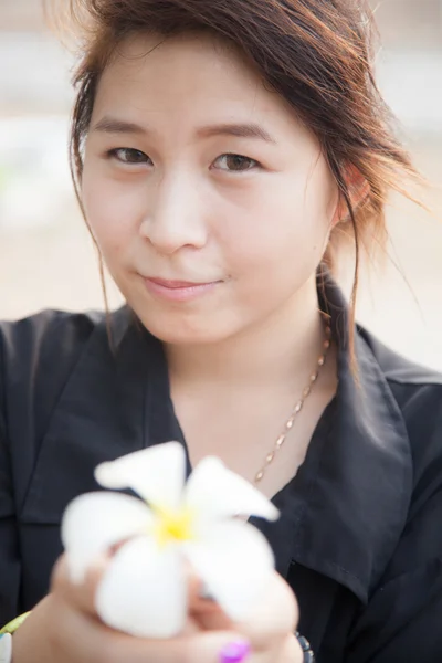 Aziatische vrouwen zwart shirt. houden van witte bloem. — Stockfoto