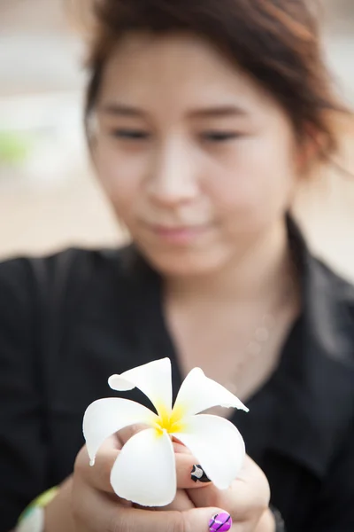 アジアの女性の黒いシャツ。白い花を保持. — ストック写真