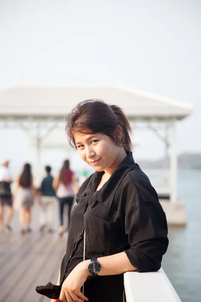 Asiatische Frauen schwarzes Hemd stehend hölzerne Terrasse — Stockfoto