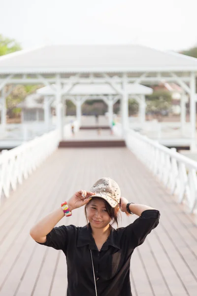 Asian women black shirt. She is wearing a hat