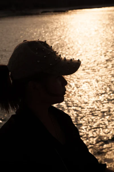 Silhouette retroilluminata di una donna che indossa un cappello . — Foto Stock