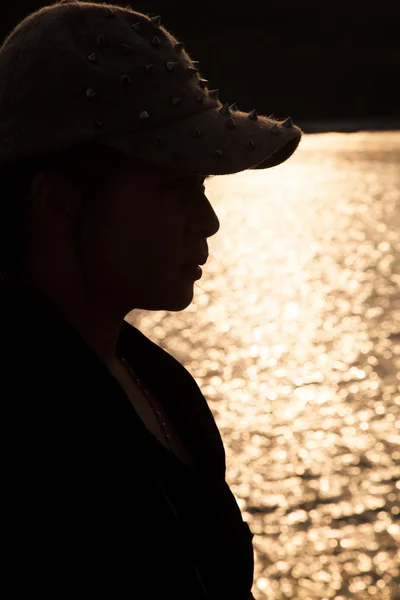 Silueta retroiluminada de una mujer con sombrero . — Foto de Stock