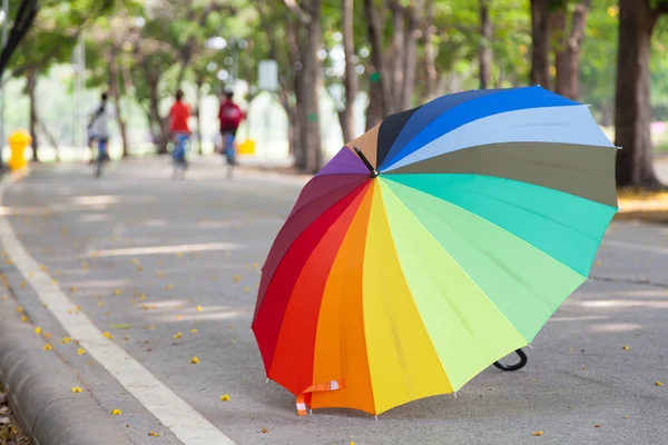Multicolored umbrella on the sidewalk. — Stock Photo, Image
