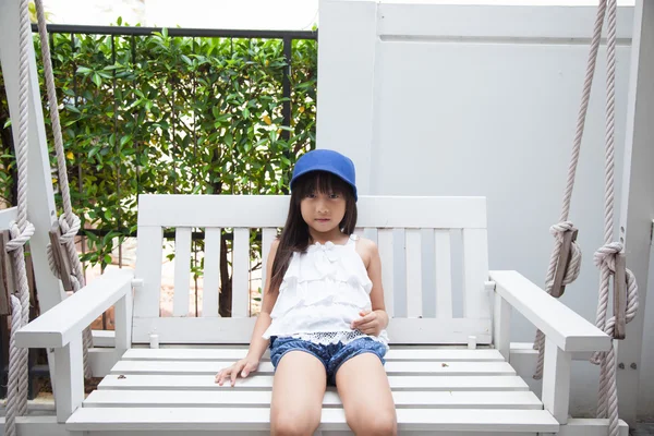 Flicka sitter på en gunga — Stockfoto