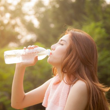 Kadın yorgun oturuyordu ve içme suyu egzersiz sonrası.
