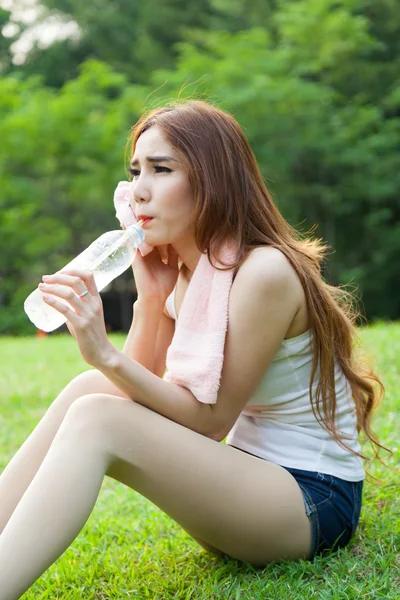 Kadın yorgun oturuyordu ve içme suyu egzersiz sonrası. — Stok fotoğraf