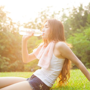 Kadın yorgun oturuyordu ve içme suyu egzersiz sonrası.