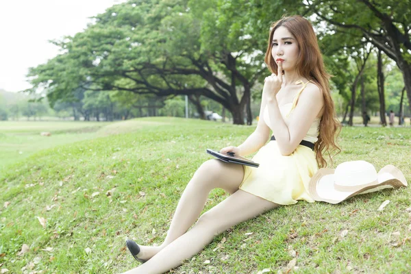 Žena sedící na trávníku — Stock fotografie