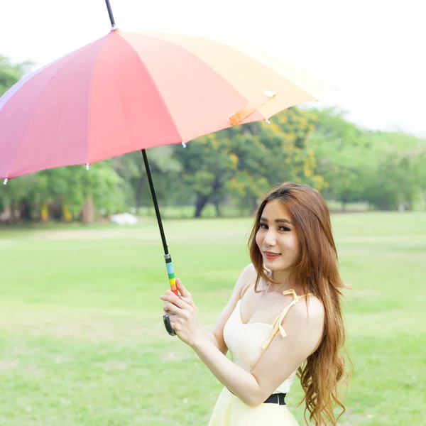 Mulher com guarda-chuva em pé no gramado . — Fotografia de Stock