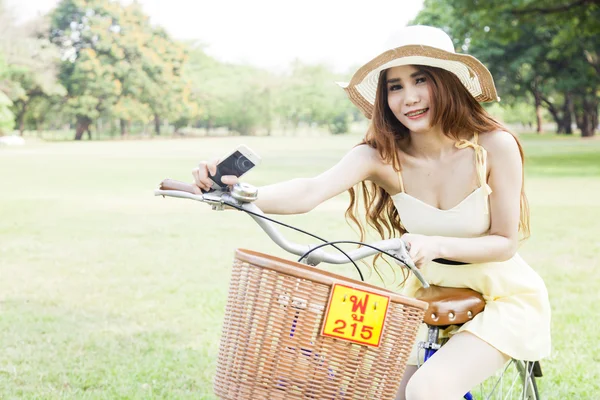 Asiatische Frau sitzt auf einem Fahrrad — Stockfoto
