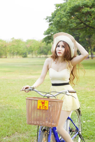 Mujer montando bicicleta en el césped . —  Fotos de Stock