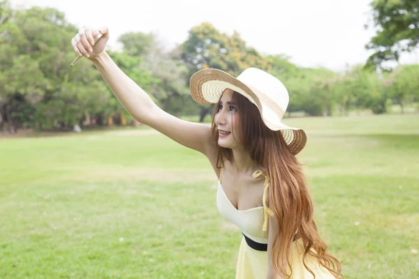 Woman working out camera phones themselves. — Stock Photo, Image