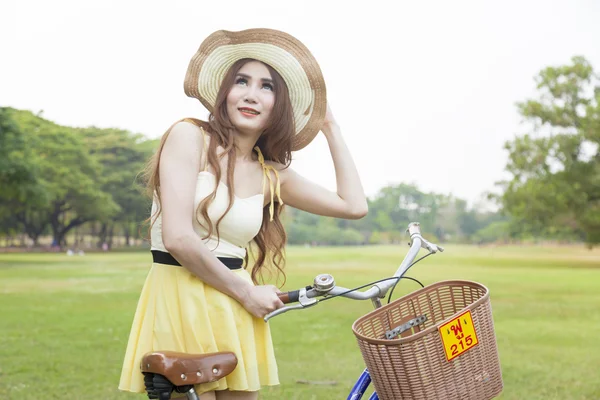 Frau mit Fahrrad auf dem Rasen — Stockfoto