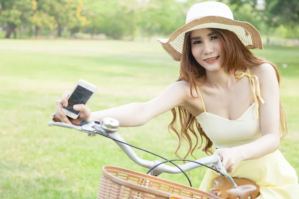 Mujer asiática sentada en una bicicleta — Foto de Stock
