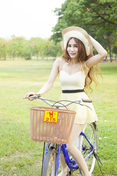 Mujer montando bicicleta en el césped . — Foto de Stock