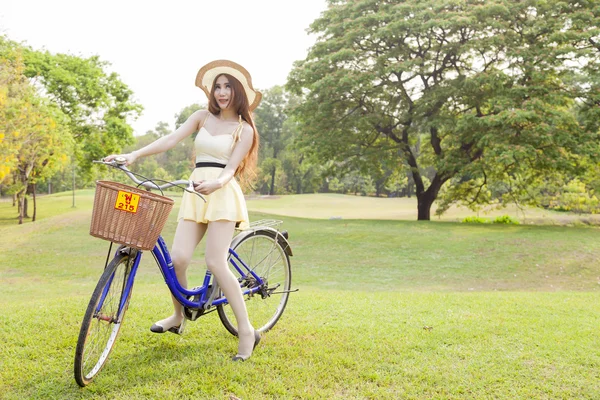 Mulher asiática montando uma bicicleta — Fotografia de Stock