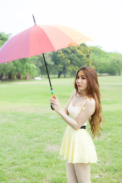 Mulher com guarda-chuva em pé no gramado . — Fotografia de Stock