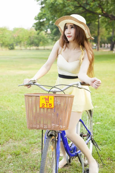 Mujer montando bicicleta en el césped . — Foto de Stock