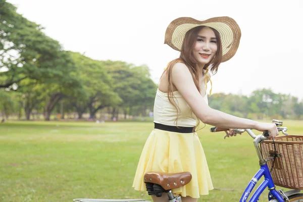 Kvinna med cykel på gräsmattan — Stockfoto
