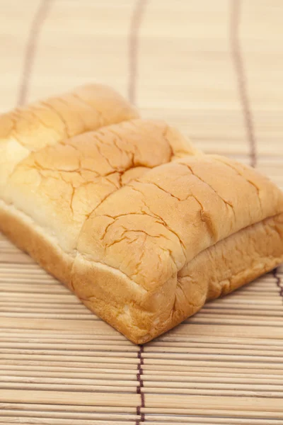 Loaf of bread on wooden plate — Stock Photo, Image