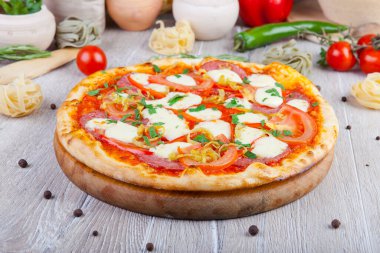 Tahta arka planda İtalyan pizzası ve dekorasyon.