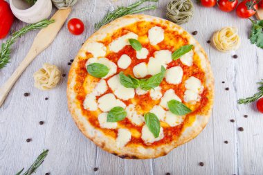 Tahta arka planda İtalyan pizzası ve dekorasyon.