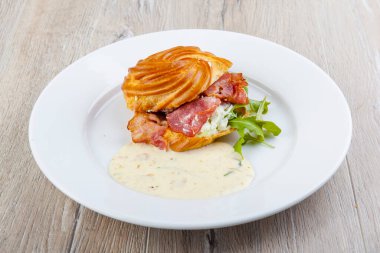 Yumurta, domuz pastırması ve peynir soslu puf.