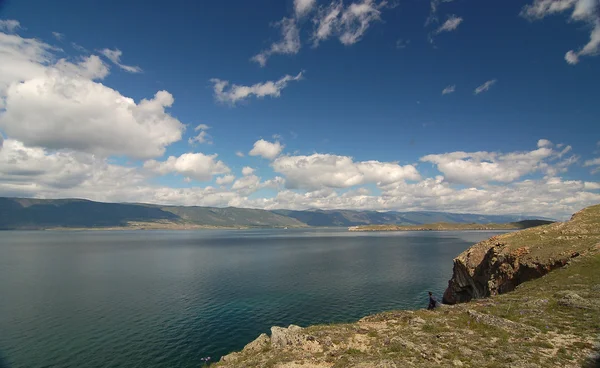 Man sits on a high bank — Stock Photo, Image