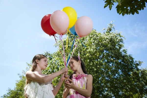 Två flickvänner med ballonger — Stockfoto