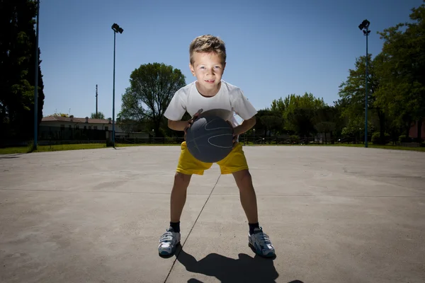 Küçük çocuk basketbol oynarken — Stok fotoğraf