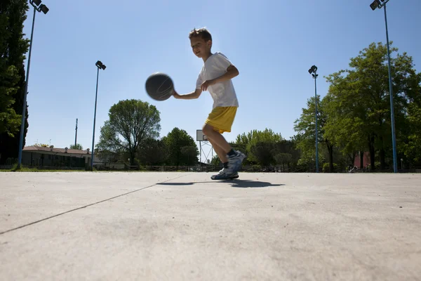 Küçük çocuk basketbol oynarken — Stok fotoğraf