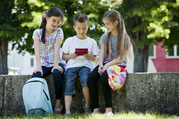 Crianças jogando jogos de vídeo ao ar livre — Fotografia de Stock