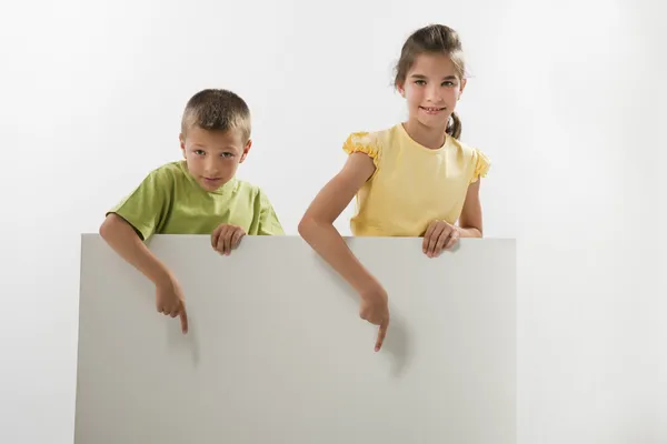 Due bambini con un segno in bianco — Foto Stock