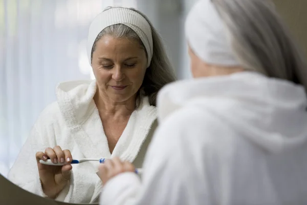 Senior mulher escovando seus dentes — Fotografia de Stock