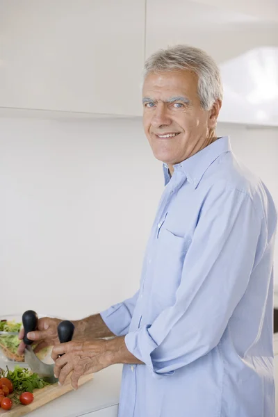 Senior man cooking — Stock Photo, Image