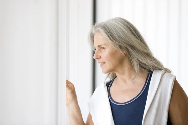 Портрет пожилой женщины у окна — стоковое фото