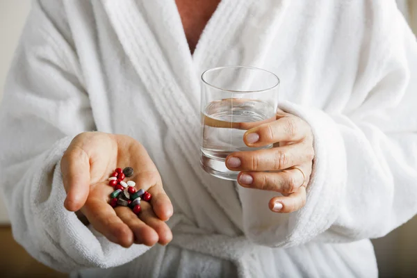 Woman with pills and water — Stock Photo, Image