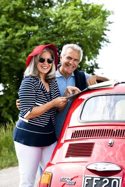 Casal sênior com carro vintage — Fotografia de Stock